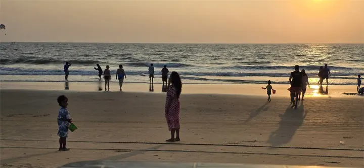Sunset at a beach with people near the shoreline